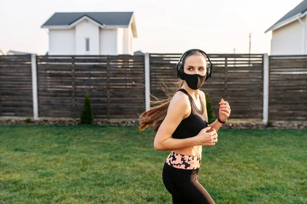 Жінка в масці робить кардіо-тренування на задньому дворі — стокове фото