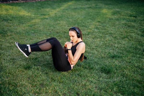 Joven mujer deportiva está haciendo sentada al aire libre — Foto de Stock