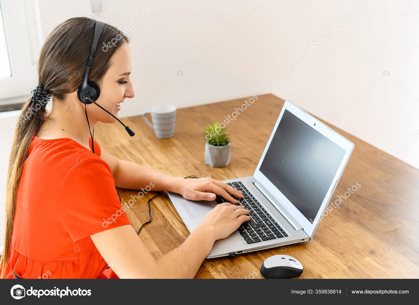 Woman works from home using headset and laptop Stock Photo by ©VadymPastukh  359838814