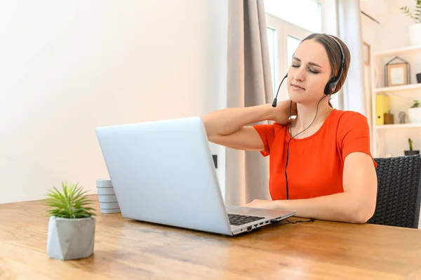 Mujer trabaja desde casa usando auriculares y portátil —  Fotos de Stock