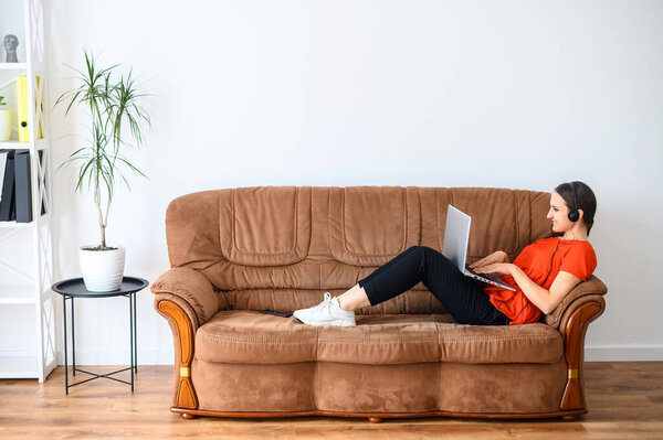 Woman works from home using laptop and headset