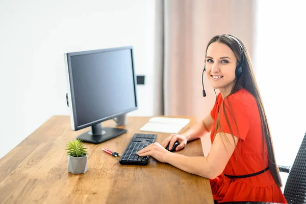İş için kulaklık ve bilgisayar kullanan kadın — Stok fotoğraf