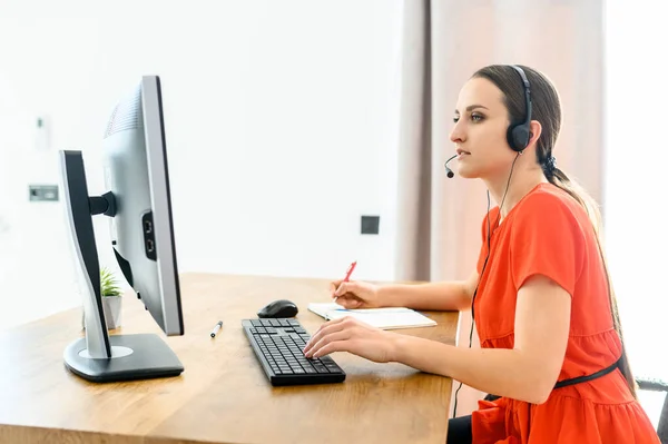 A nő fejhallgatót és pc-t használ a munkához — Stock Fotó