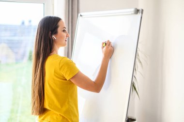 Woman with a marker making notes on a white board clipart