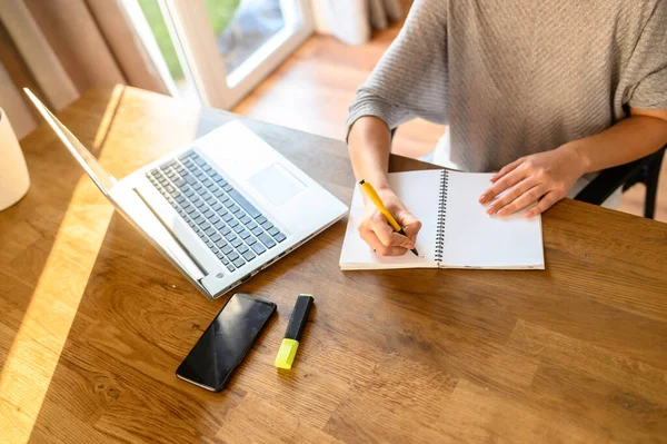 Eine junge Frau sitzt an einem Tisch mit einem Laptop — Stockfoto