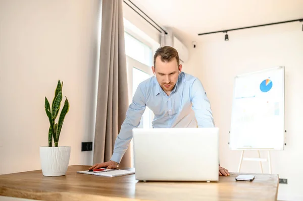 En ung affärsman i en smart casual använder laptop — Stockfoto