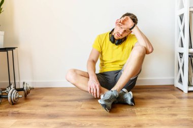 Genç aktif adam evde egzersiz yapıyor.