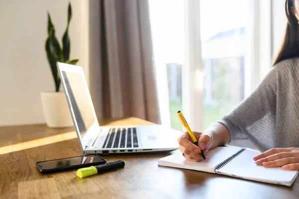 Une jeune femme s'assoit à une table avec un ordinateur portable — Photo