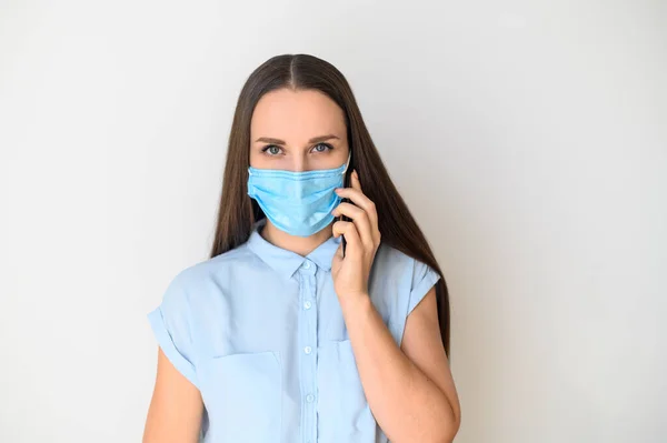 Junge Frau mit medizinischer Maske und Smartphone — Stockfoto