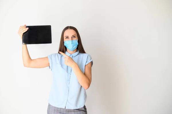 Junge Frau in medizinischer Maske mit Tablette — Stockfoto