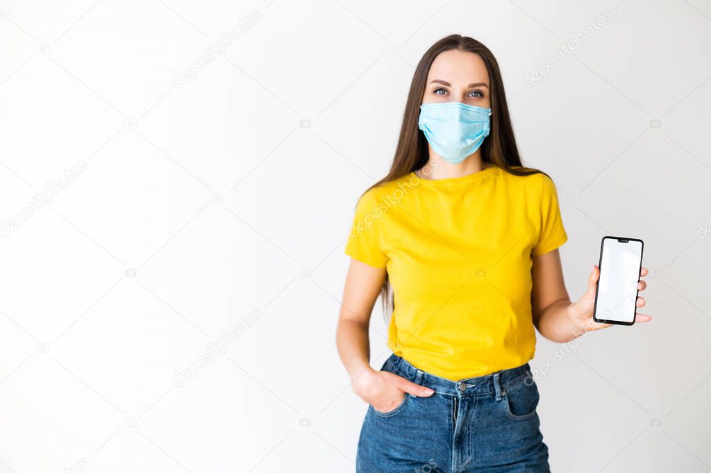 Woman in medical mask shows her phone screen