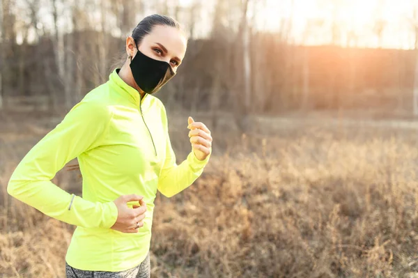 Жінка в медичній масці біжить на відкритому повітрі — стокове фото