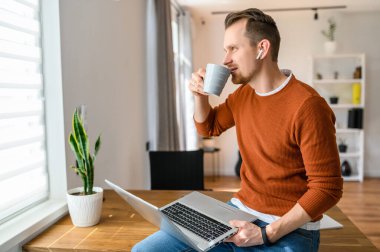 Adam çalışmak için dizüstü bilgisayar kullanıyor.