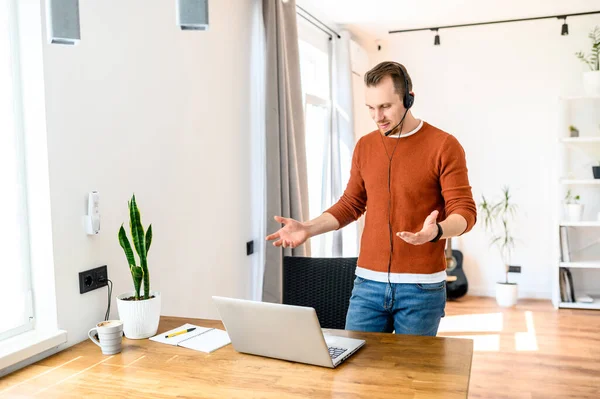 Een man gebruikt een headset voor videogesprekken. — Stockfoto