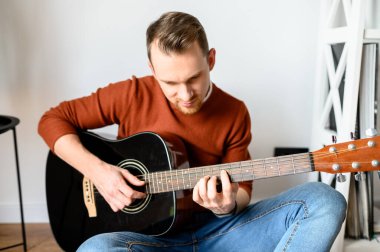 Akustik gitarlı çekici bir genç.