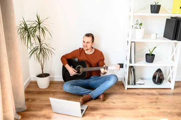 Een man kijkt video tutorial op gitaar spelen — Stockfoto