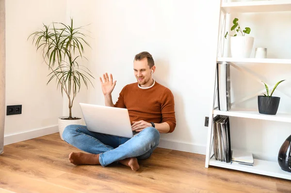 A young guy uses a laptop for a video call