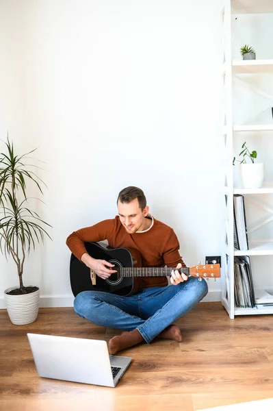 Een man kijkt video tutorial op gitaar spelen — Stockfoto