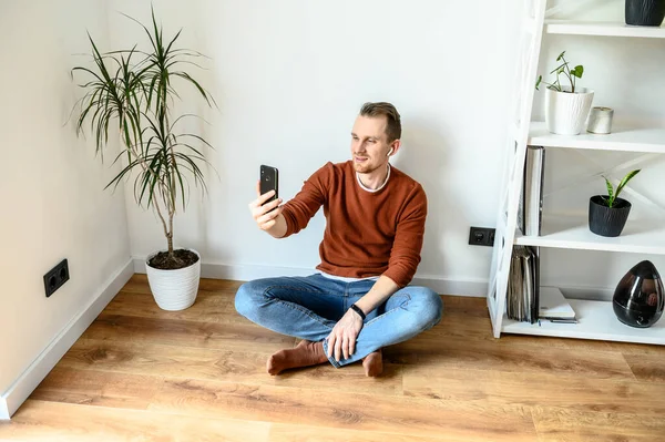 A young guy uses a smartphone for a video call
