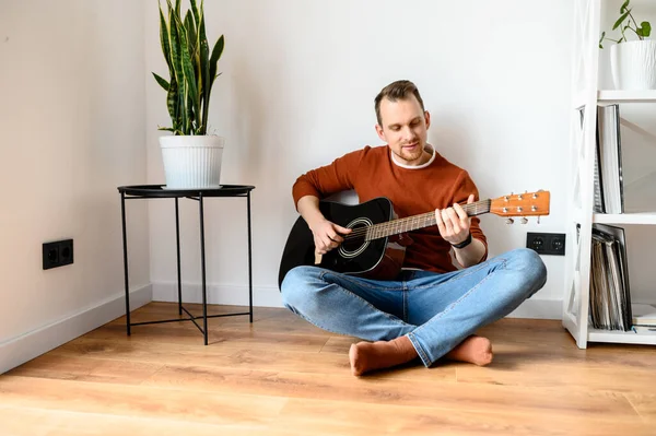 Giovane ragazzo attraente con una chitarra acustica — Foto Stock