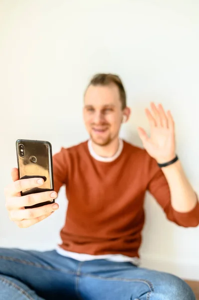 A young guy uses a smartphone for a video call