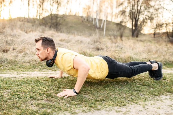 stock image Attractive guy in headphones doing outdoor workout