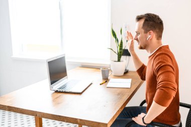 Genç sakallı bir adam video kullanarak konuşuyor.