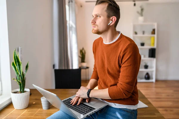 Hij gebruikt een laptop om te werken. — Stockfoto