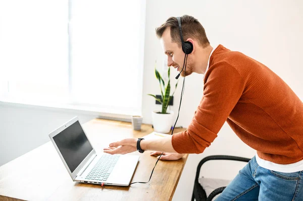 Un tipo usa un auricular para una videollamada —  Fotos de Stock