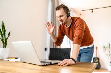 Bir adam video görüşmesi için kulaklık kullanıyor.