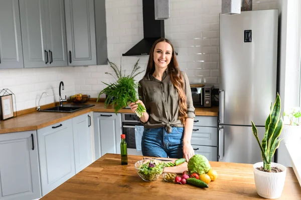 Una donna con un mucchio di aneto che prepara un'insalata — Foto Stock