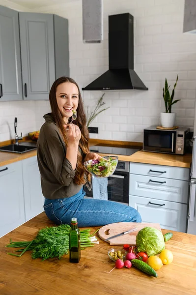 Una donna sta mangiando un'insalata fresca da una ciotola — Foto Stock