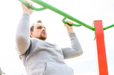 Bir adam dışarıda vücut ağırlığı egzersizi yapıyor.