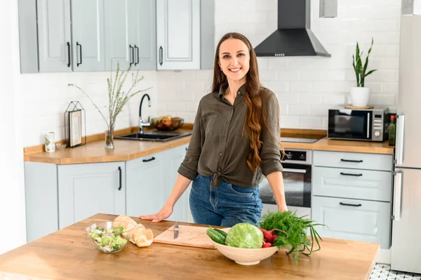 Donna in abbigliamento casual sta cucinando in cucina a casa — Foto Stock