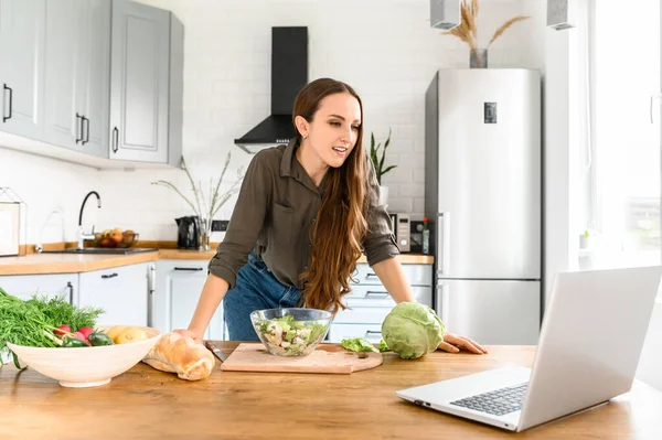 Mulher assistindo cozinhar vídeo na cozinha — Fotografia de Stock