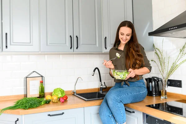 Una donna sta mangiando un'insalata fresca da una ciotola — Foto Stock