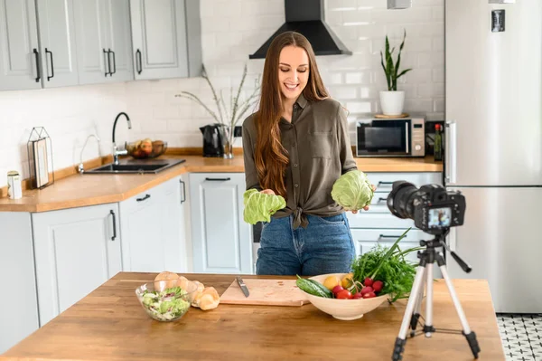 A young woman is recording video cooking lessons