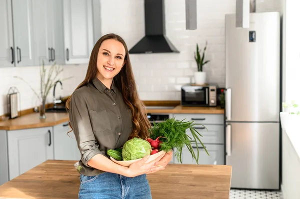 Giovane donna che tiene un cesto di verdure fresche — Foto Stock