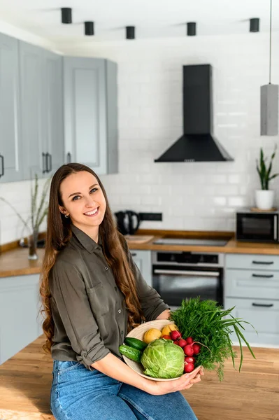 Giovane donna che tiene un cesto di verdure fresche — Foto Stock