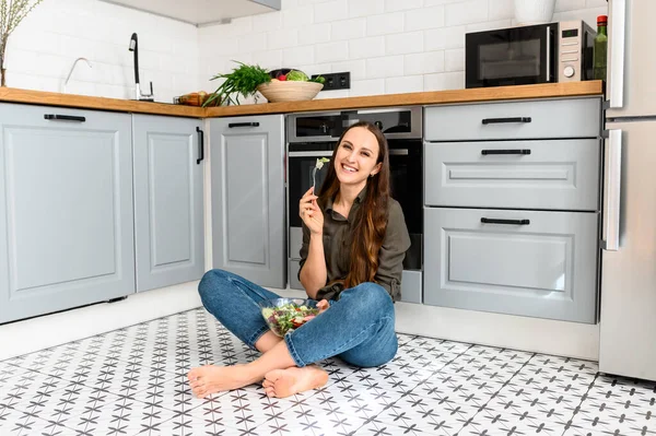 Una donna sta mangiando un'insalata fresca da una ciotola — Foto Stock