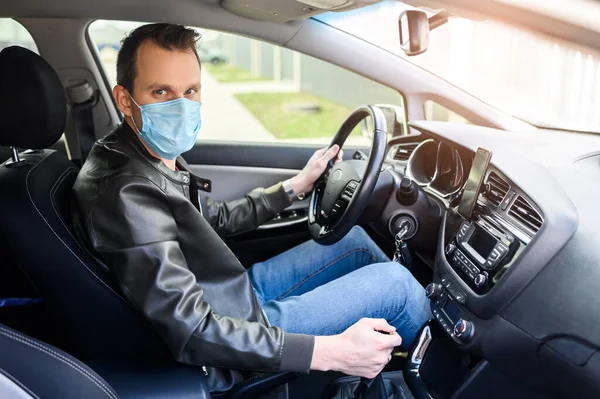 Молодий чоловік у захисній масці водить машину — стокове фото