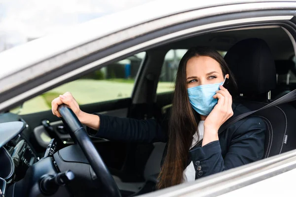 Junge Frau mit Schutzmaske fährt Auto — Stockfoto