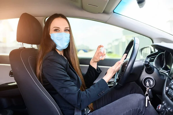 Молодая женщина в защитной маске водит машину — стоковое фото