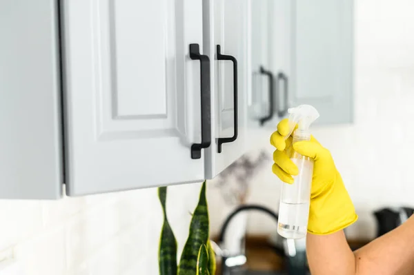 Hands in a gloves is cleaning the kitchen cabinets — Stock Photo, Image