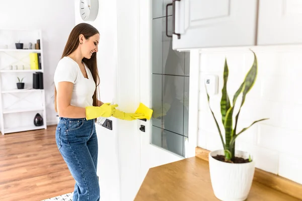 Mujer joven en guantes de goma haciendo limpieza de la casa —  Fotos de Stock