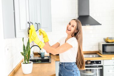 Lastik eldivenli genç kadın ev temizliği yapıyor.