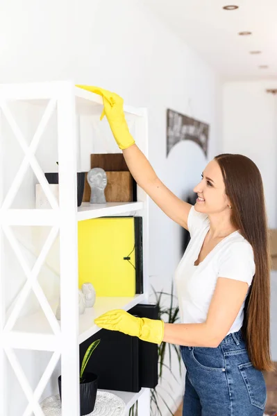 Mladá žena v gumových rukavicích dělá úklid domu — Stock fotografie
