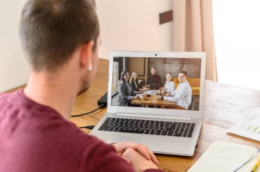 Bir adam videoyla iş arkadaşlarıyla bağlantı kurar