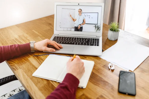 Un jeune homme étudie en ligne, regarde des webinaires — Photo