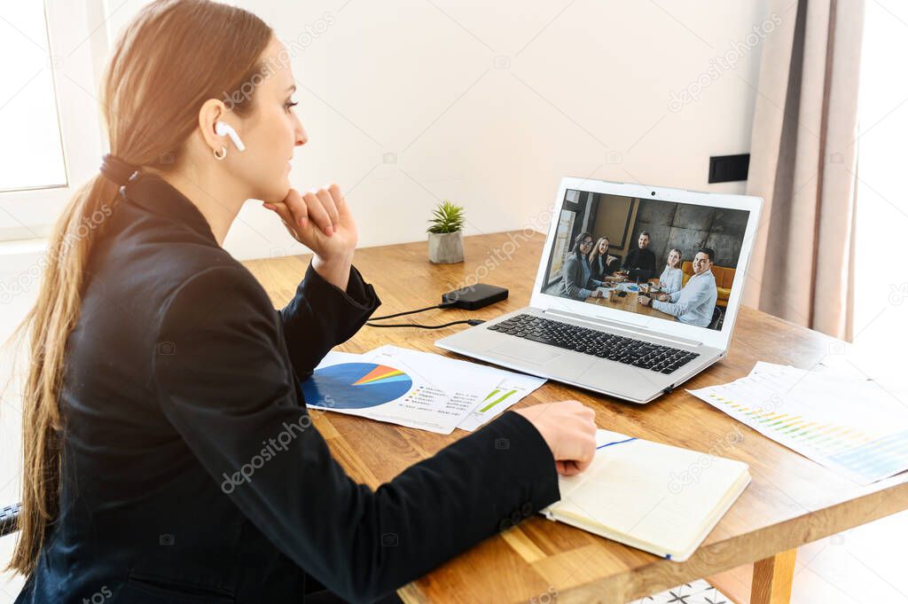 A young woman connects via video with coworkers